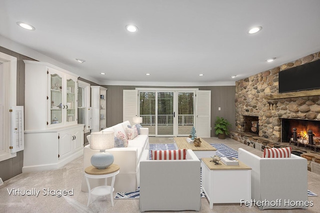 living room with recessed lighting, light carpet, and a stone fireplace