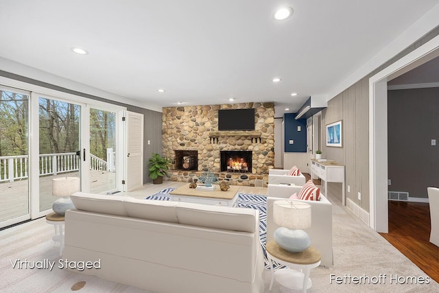 living area with a fireplace, visible vents, wood finished floors, and recessed lighting