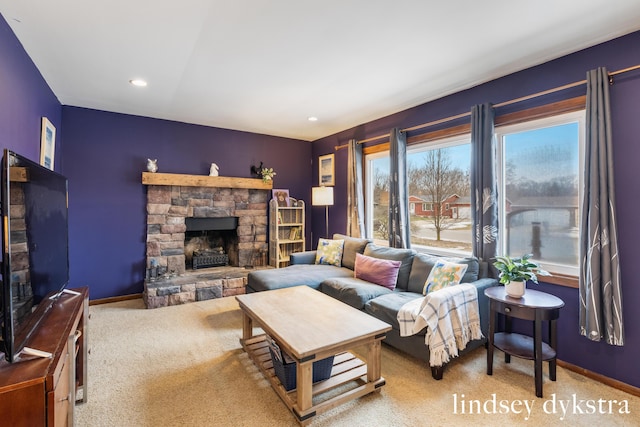 living room featuring carpet, a stone fireplace, baseboards, and recessed lighting