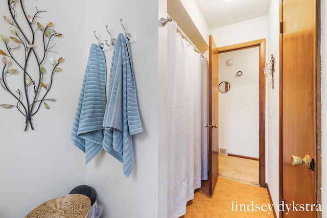 full bathroom with wood finished floors, visible vents, and baseboards