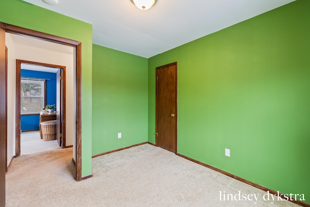 carpeted spare room featuring baseboards