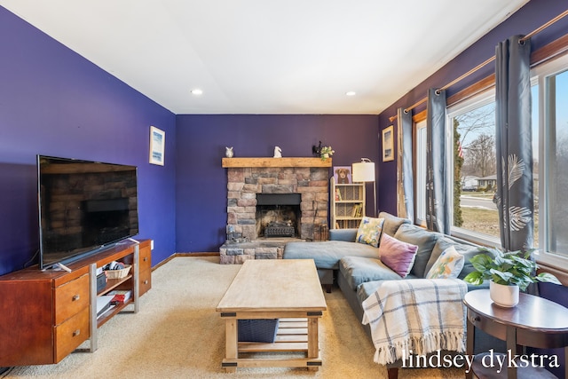 carpeted living room featuring recessed lighting, a stone fireplace, and baseboards