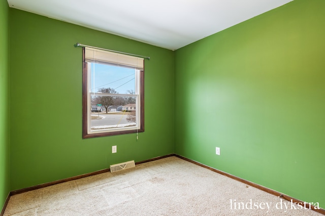 spare room with baseboards, visible vents, and carpet flooring