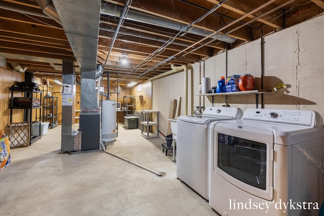 unfinished below grade area featuring heating unit, water heater, and independent washer and dryer