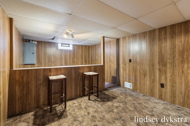 bar featuring a paneled ceiling, wooden walls, visible vents, and carpet flooring