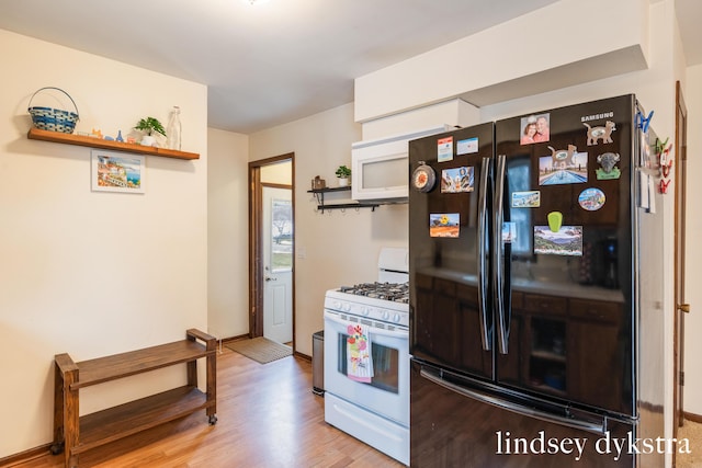 kitchen featuring wood finished floors, white appliances, baseboards, and open shelves