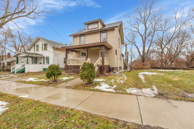 american foursquare style home with covered porch and a front lawn