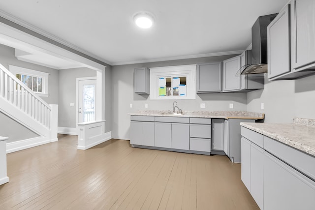 kitchen with light countertops, gray cabinets, light wood-type flooring, and a sink