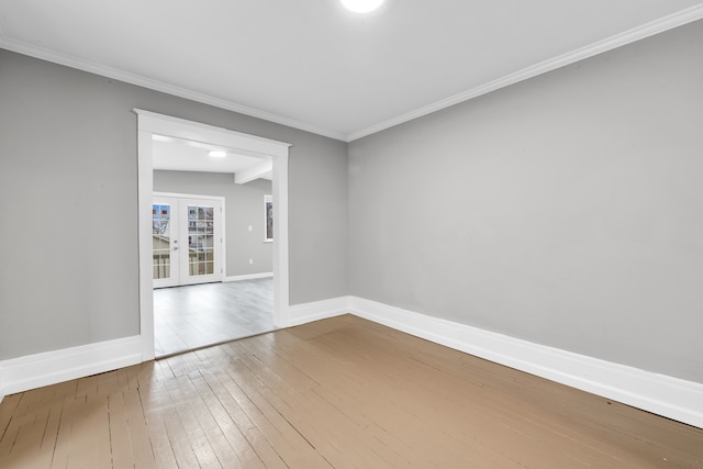 empty room with crown molding, french doors, hardwood / wood-style floors, and baseboards