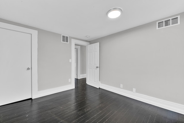 unfurnished bedroom with baseboards, visible vents, and dark wood-style flooring