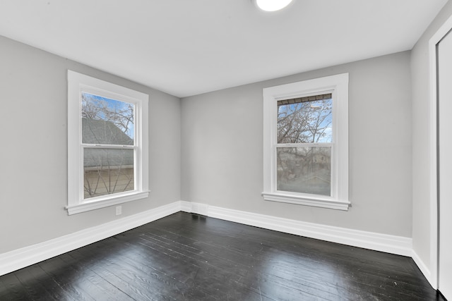 unfurnished room with dark wood-style floors, plenty of natural light, and baseboards