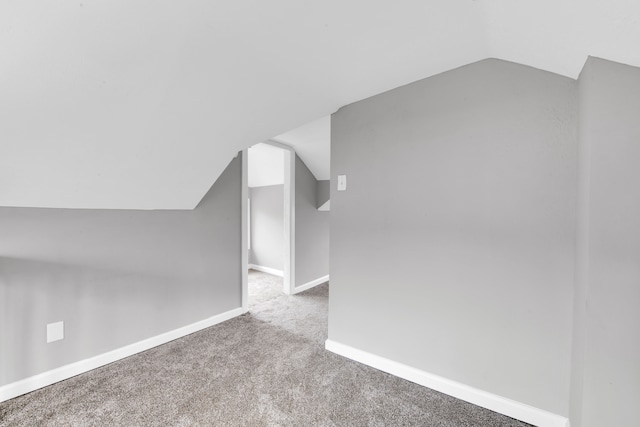 bonus room featuring lofted ceiling, carpet, and baseboards