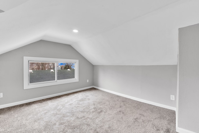 bonus room featuring lofted ceiling, carpet floors, and baseboards