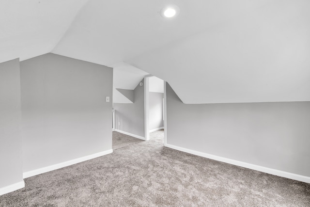 additional living space with carpet floors, vaulted ceiling, and baseboards