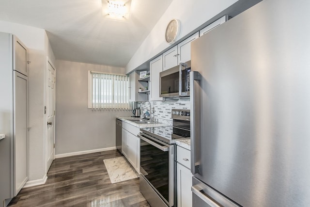 kitchen featuring appliances with stainless steel finishes, dark wood-style flooring, a sink, open shelves, and backsplash