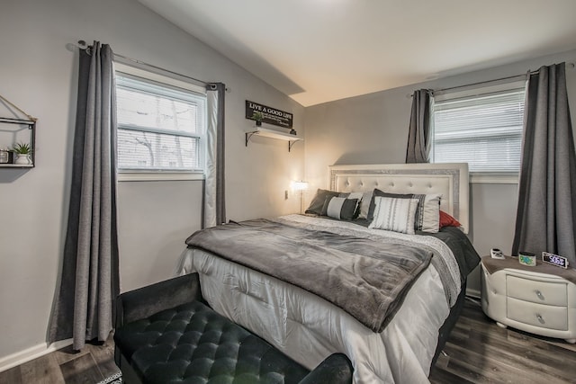 bedroom featuring baseboards, vaulted ceiling, and wood finished floors