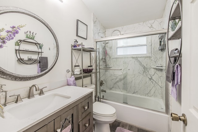 full bathroom with enclosed tub / shower combo, wood finished floors, vanity, and toilet