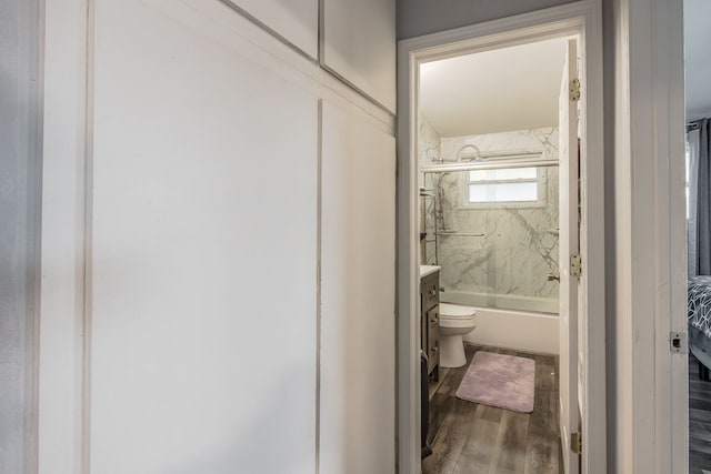 full bathroom featuring shower / bath combination with glass door, vanity, toilet, and wood finished floors