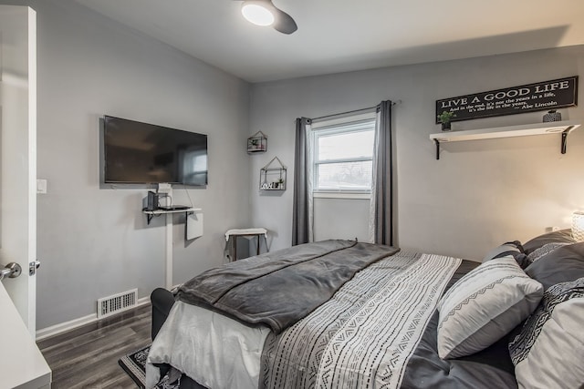 bedroom featuring baseboards, visible vents, ceiling fan, and wood finished floors