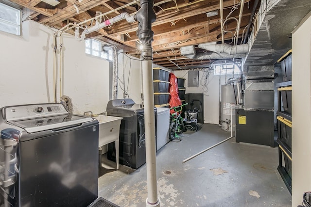 below grade area with a sink, washing machine and dryer, electric panel, and gas water heater