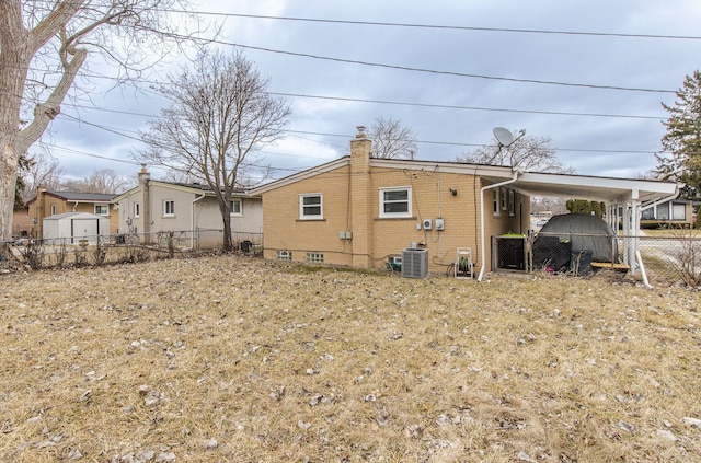 back of property featuring cooling unit, brick siding, fence, and a chimney