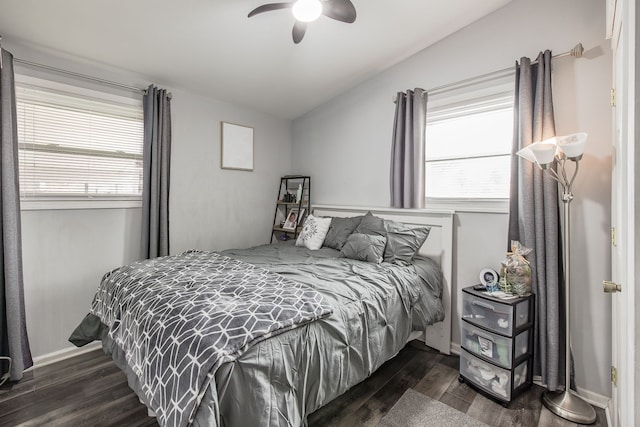 bedroom with lofted ceiling, multiple windows, and dark wood-style flooring