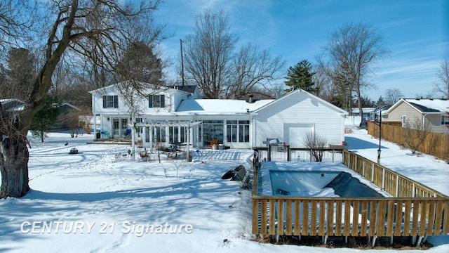 snow covered rear of property with fence