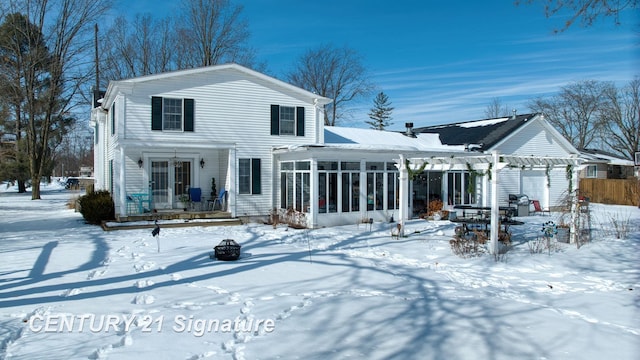 snow covered property featuring an outdoor fire pit, a sunroom, and a pergola