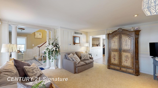 living area featuring visible vents, light colored carpet, stairway, ornate columns, and a decorative wall