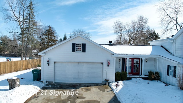 view of front of house featuring a garage, french doors, and fence