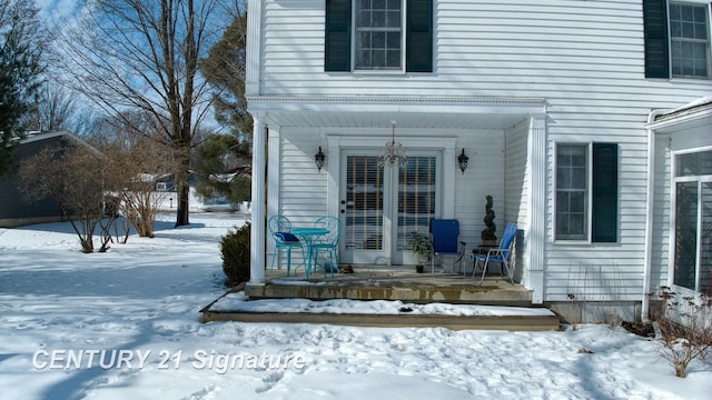 snow covered property entrance with covered porch