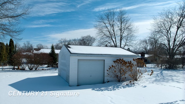 snow covered garage with a garage