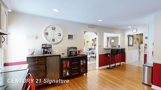 bar featuring wainscoting, wood finished floors, and recessed lighting