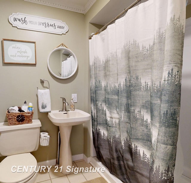 full bathroom featuring toilet, a sink, tile patterned floors, baseboards, and a shower with curtain