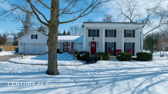 greek revival inspired property with a garage, french doors, and fence