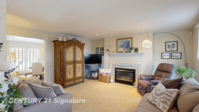 living room featuring ornamental molding, a glass covered fireplace, and light carpet