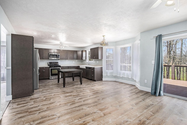 kitchen featuring light wood-style flooring, appliances with stainless steel finishes, light countertops, and dark brown cabinets