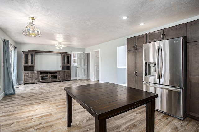 kitchen featuring a textured ceiling, light wood-style floors, dark brown cabinets, stainless steel refrigerator with ice dispenser, and plenty of natural light