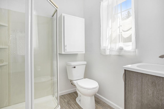 full bath with baseboards, wood finished floors, toilet, and a shower stall