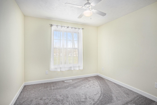 carpeted empty room featuring visible vents, ceiling fan, a textured ceiling, and baseboards