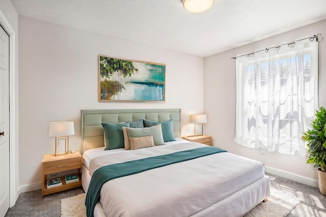 carpeted bedroom featuring baseboards