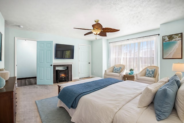 bedroom with a ceiling fan, a textured ceiling, and baseboards