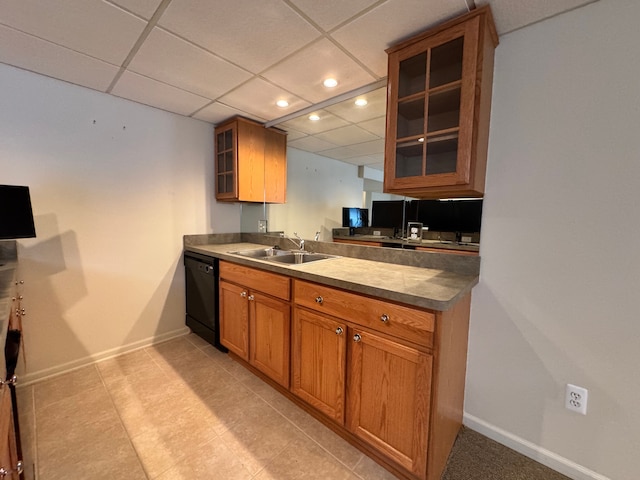 kitchen featuring brown cabinetry, dishwasher, glass insert cabinets, and a sink