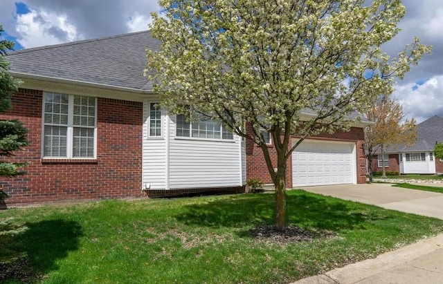 view of front facade featuring brick siding, an attached garage, concrete driveway, and a front yard