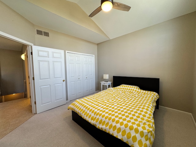 bedroom featuring a ceiling fan, visible vents, carpet floors, vaulted ceiling, and a closet