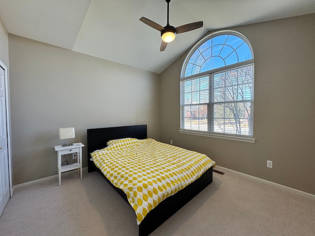 carpeted bedroom featuring lofted ceiling, visible vents, baseboards, and ceiling fan