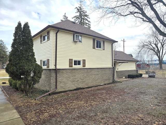 view of side of property featuring fence and brick siding