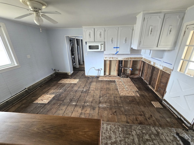 7993 Church Rd, Grosse Ile, MI 48138 - kitchen with white microwave, ceiling fan, dark wood-style floors, light countertops, and white cabinetry
