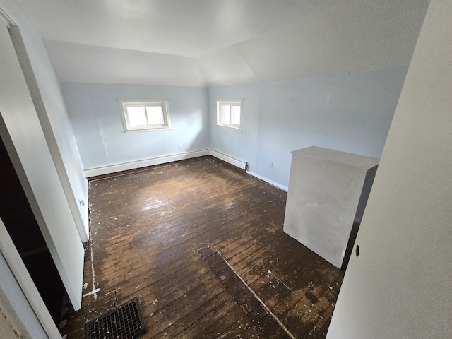 7993 Church Rd, Grosse Ile, MI 48138 - spare room featuring lofted ceiling, wood-type flooring, baseboards, and a baseboard radiator