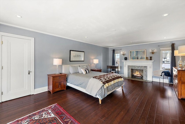 bedroom featuring crown molding, multiple windows, dark wood-style floors, and a fireplace with flush hearth